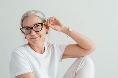 Femme à lunettes assise à son poste de travail