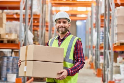 Manutentionnaire portant des cartons dans un entrepôt
